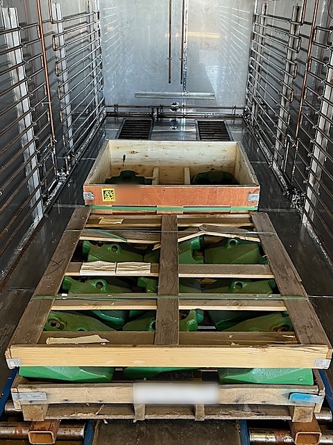 Crated green castings on pallets inside a DCI chamber