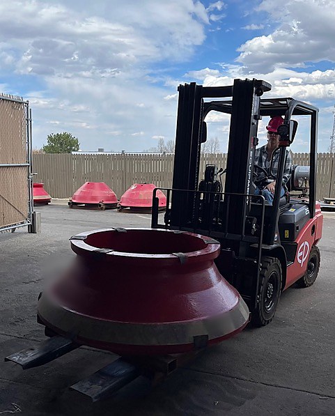 Linda Williams moving a cone crusher mantle with a forklift