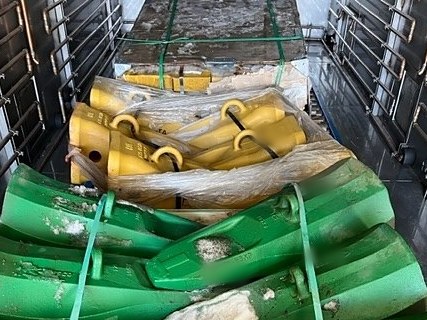 Shovel teeth and adapters strapped on pallets between the rails of a DCI chamber